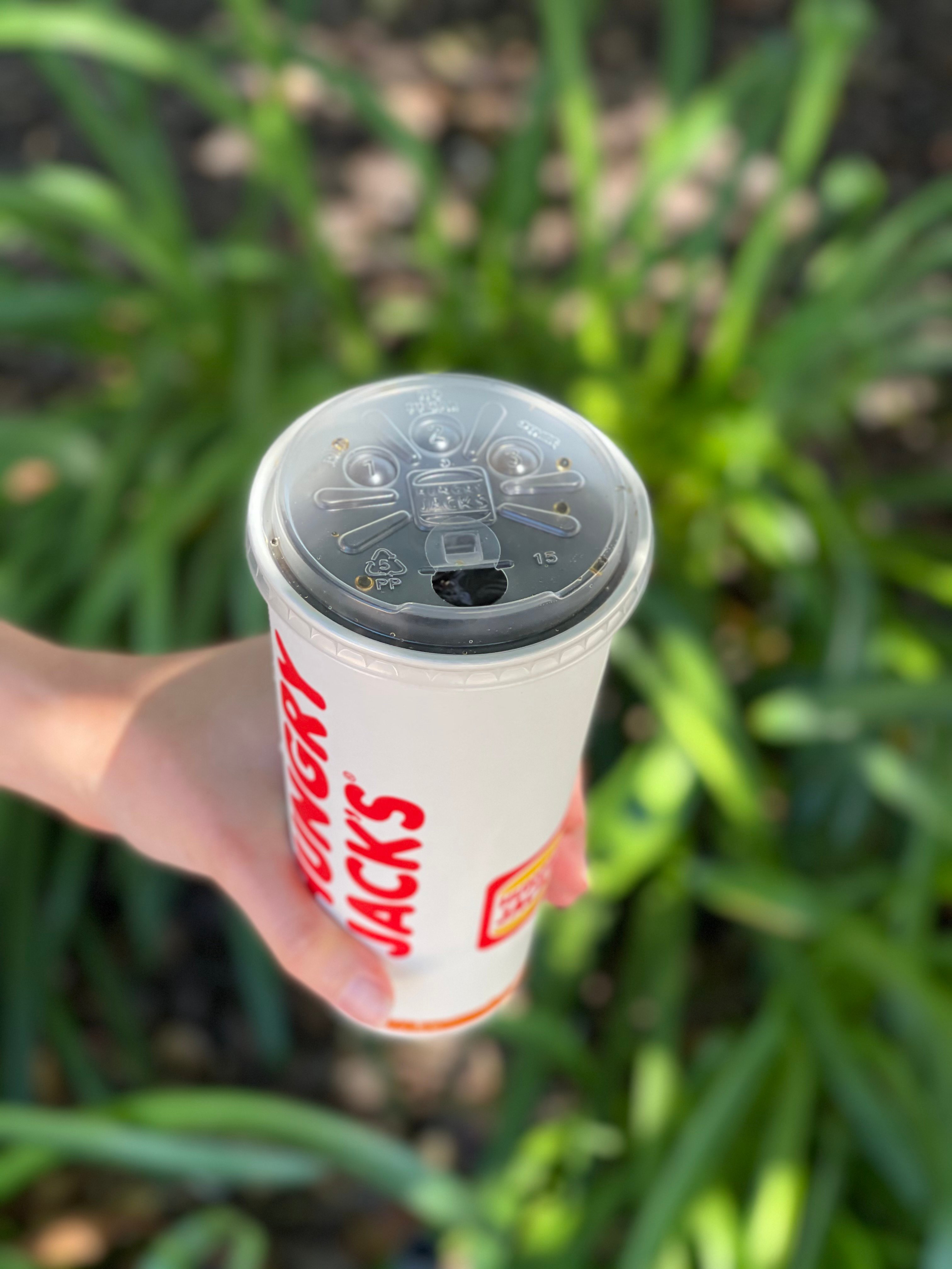 Hungry Jack's strawless lid sealing cup of Coca-Cola. 