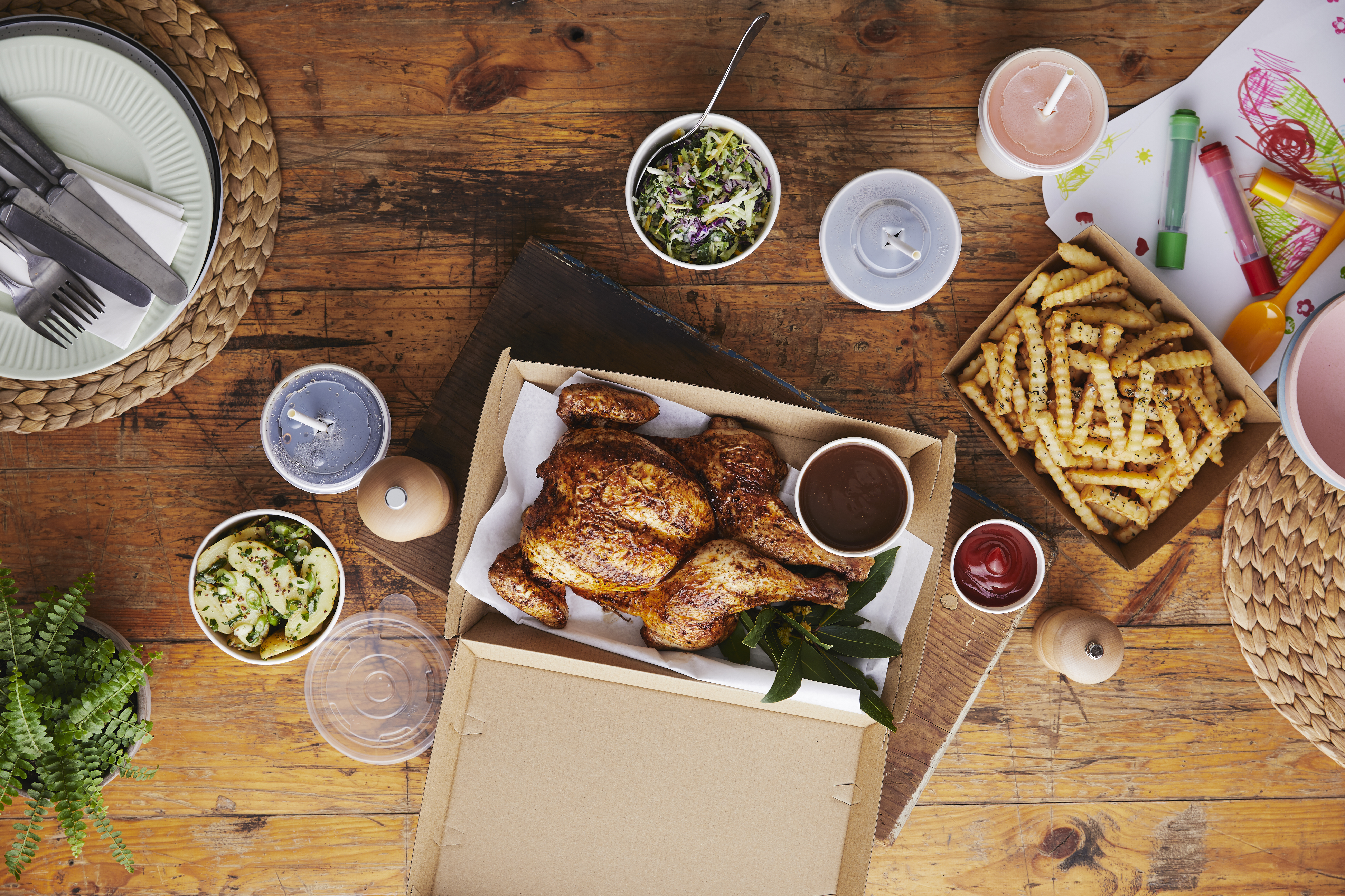 Takeaway chicken and chips in kraft cartons served at home. 