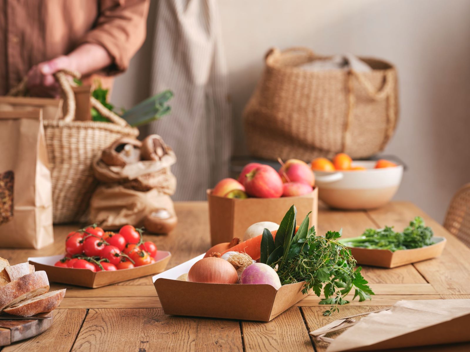 Detpak recyclable market trays filled with fresh produce laid out on dining table. 