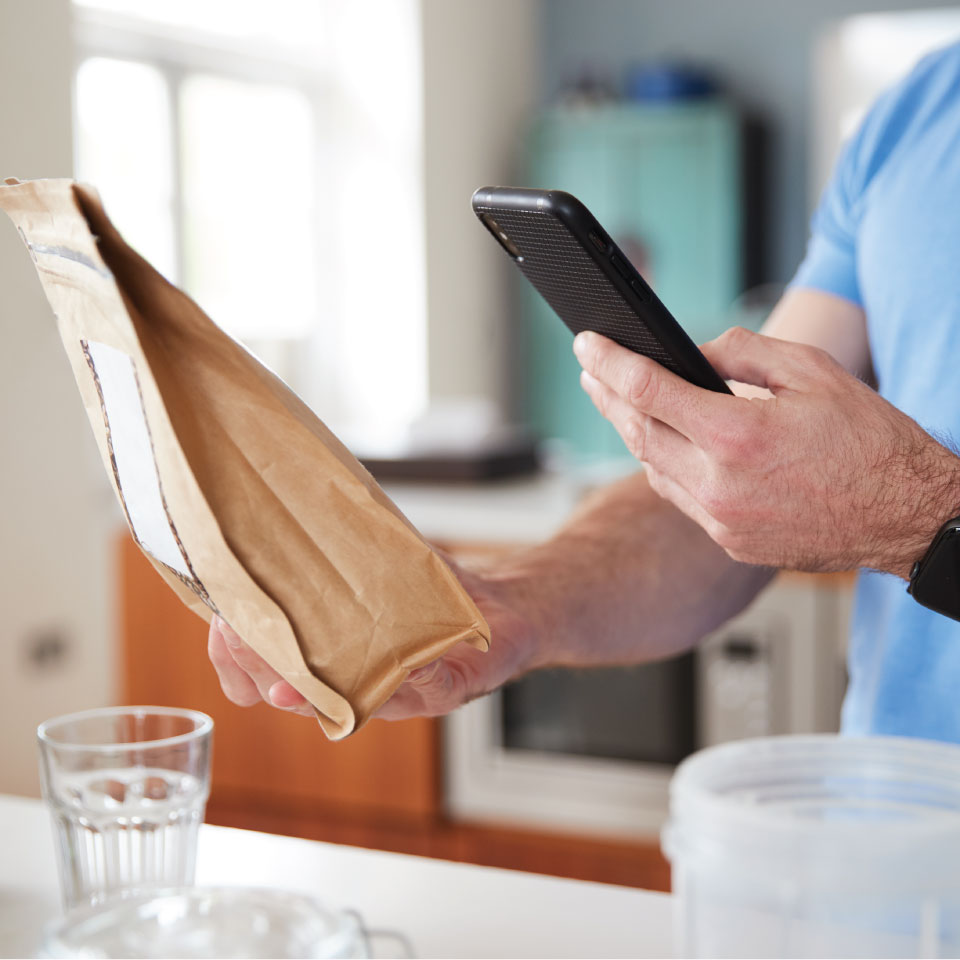 Man scanning QR code on paper bag.