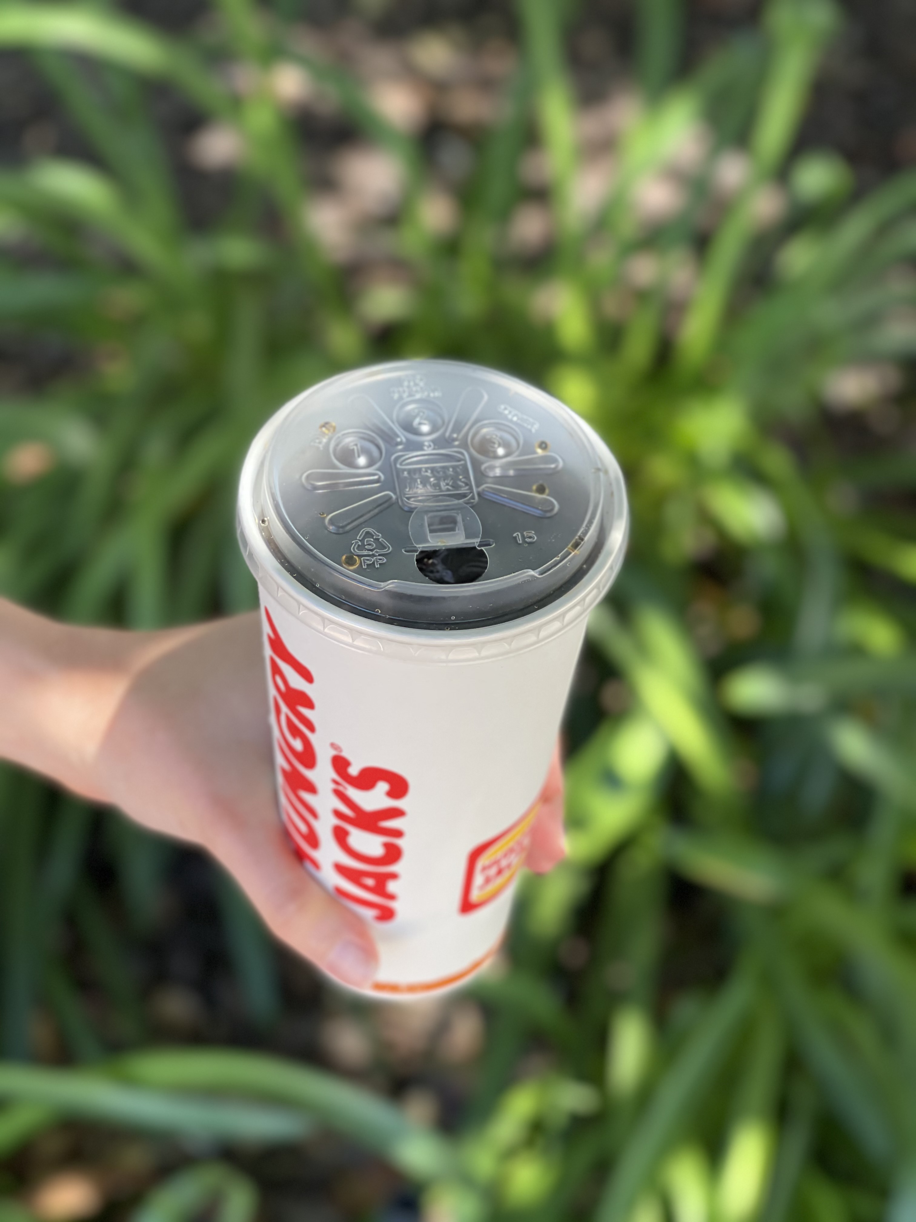 Hungry Jack's strawless lid sealing cup of Coca-Cola. 