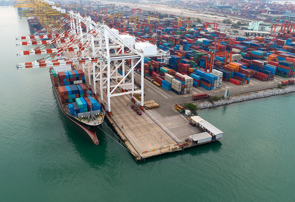 Image of a port with a ship being loaded with containers