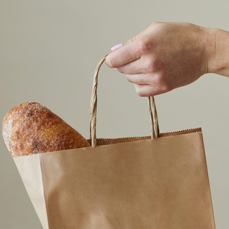 Person holding a recyclable Detpak carry bag