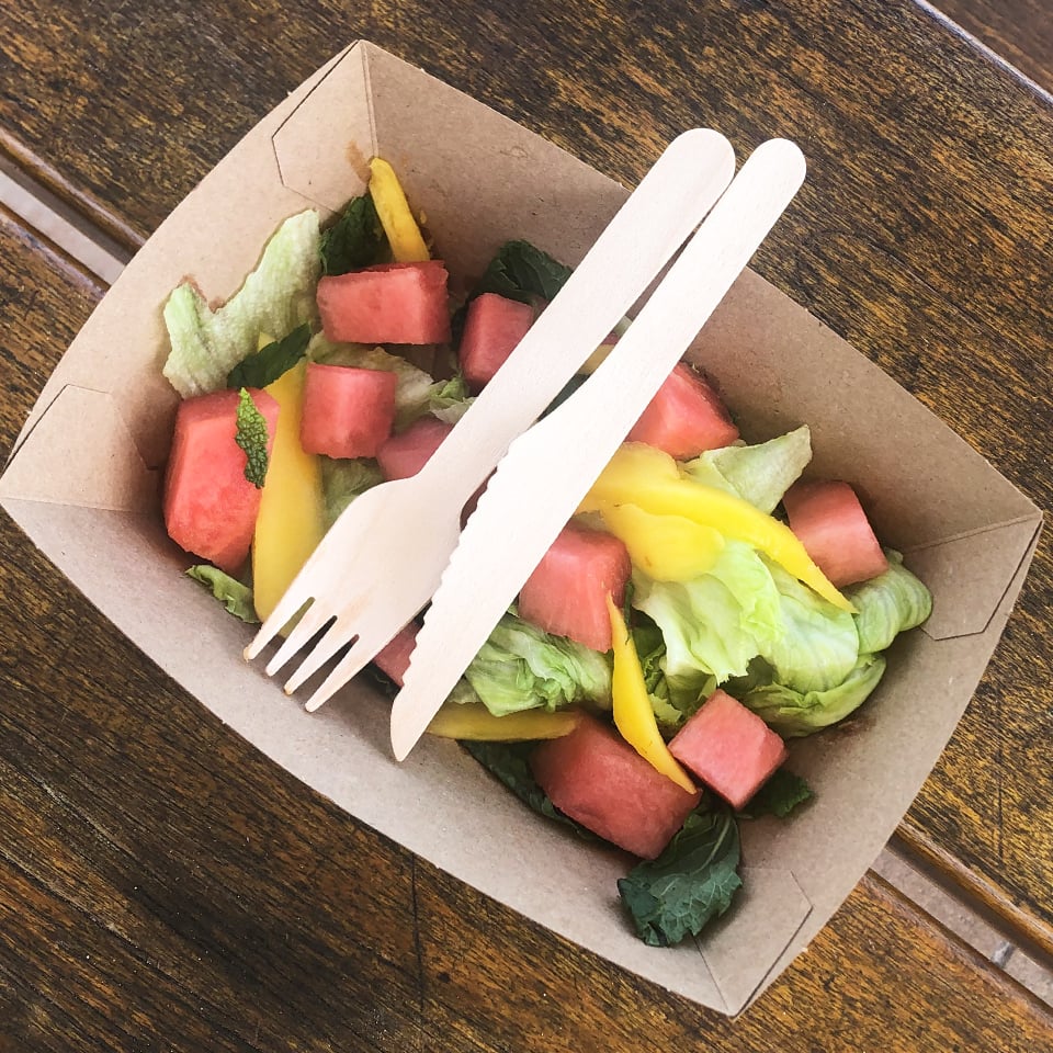 Endura tray filled with salad and pictured with wooden cutlery. 