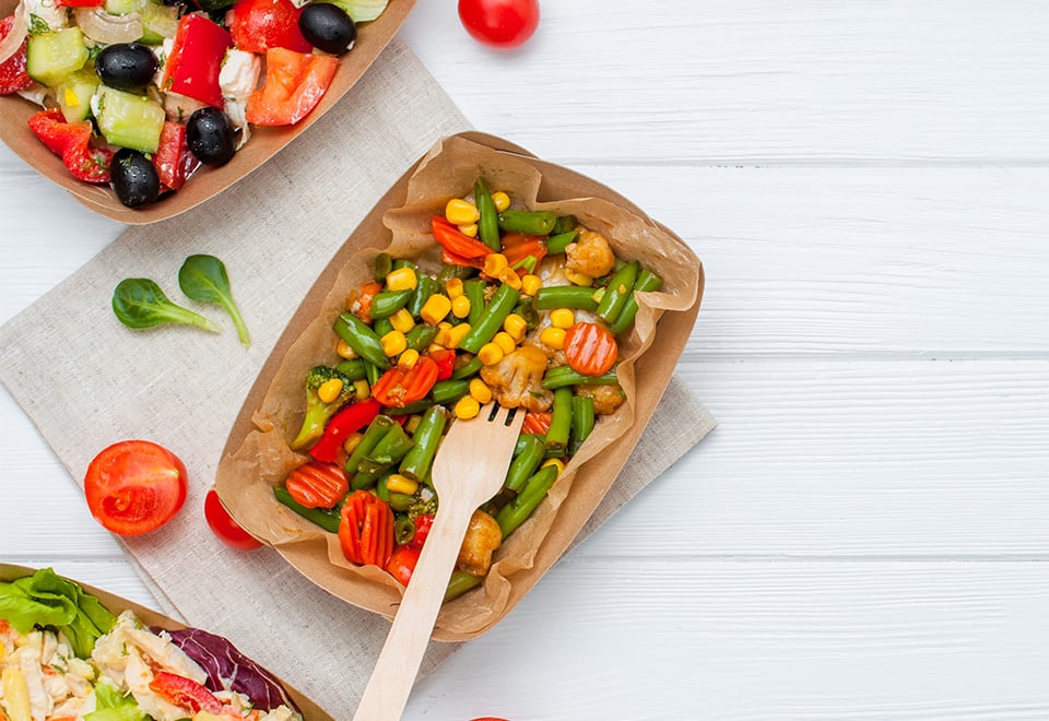 Endura tray filled with salad and pictured with a wooden fork. 